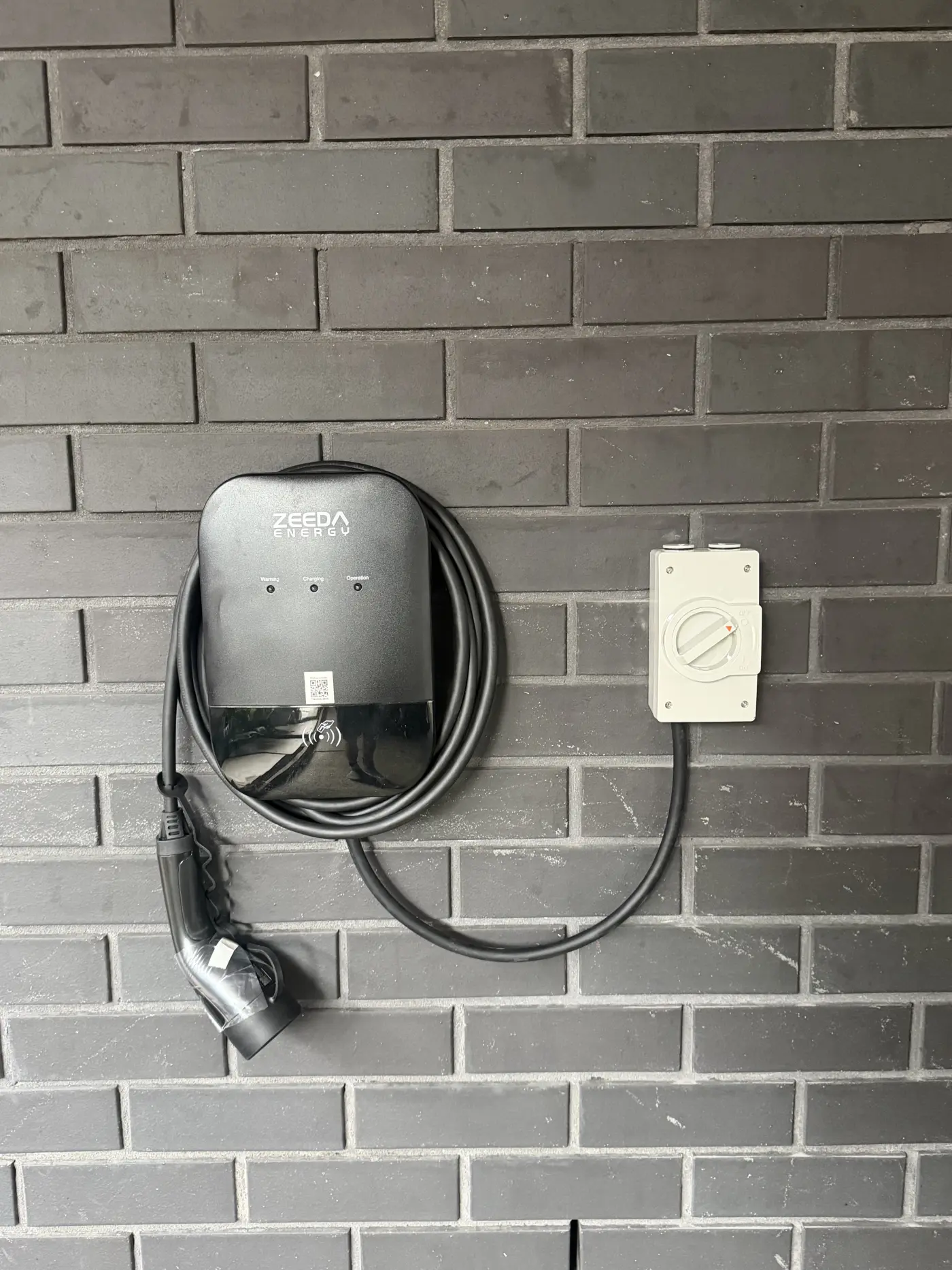 EV charger and isolator installed on a brick wall