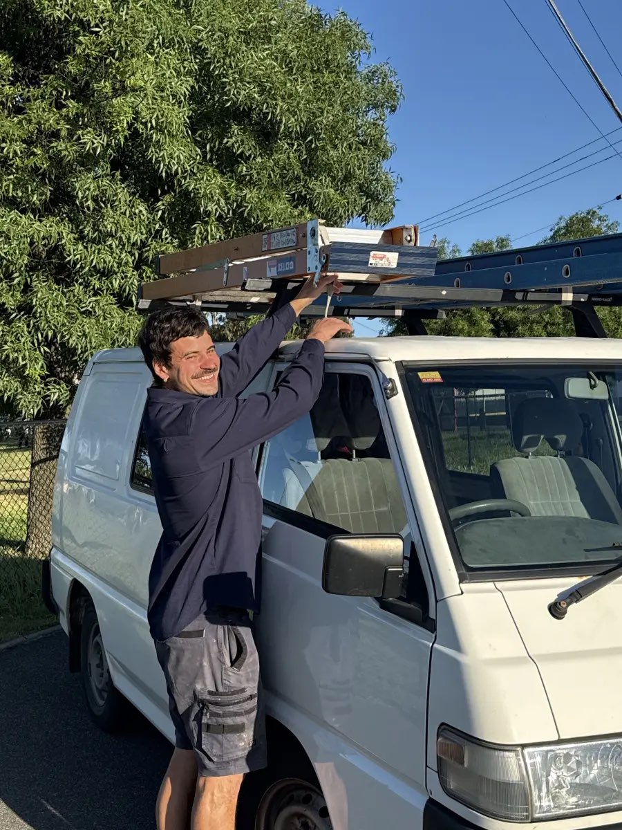 Jack, licensed electrician at Pender Electrical, loading a ladder onto his van in Melbourne's inner north