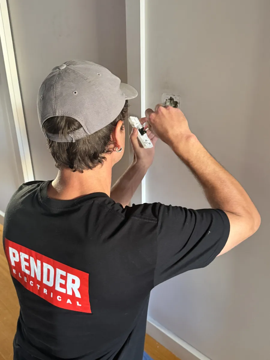 Jack from Pender Electrical fitting a new power point during a house rewire in Melbourne's inner north